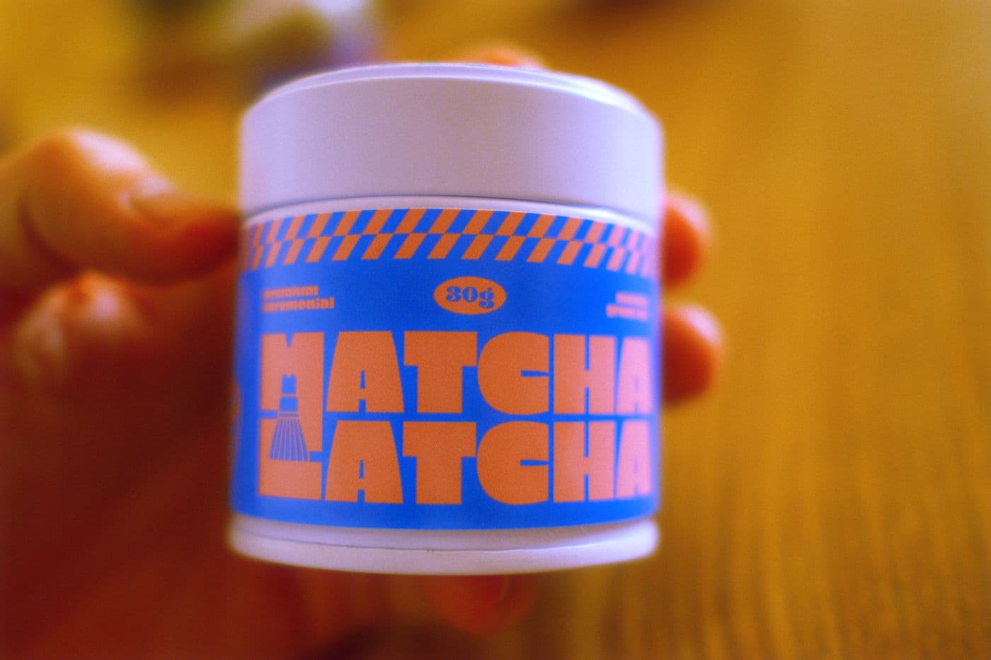 Matcha Latcha tin held in a hand at sunset